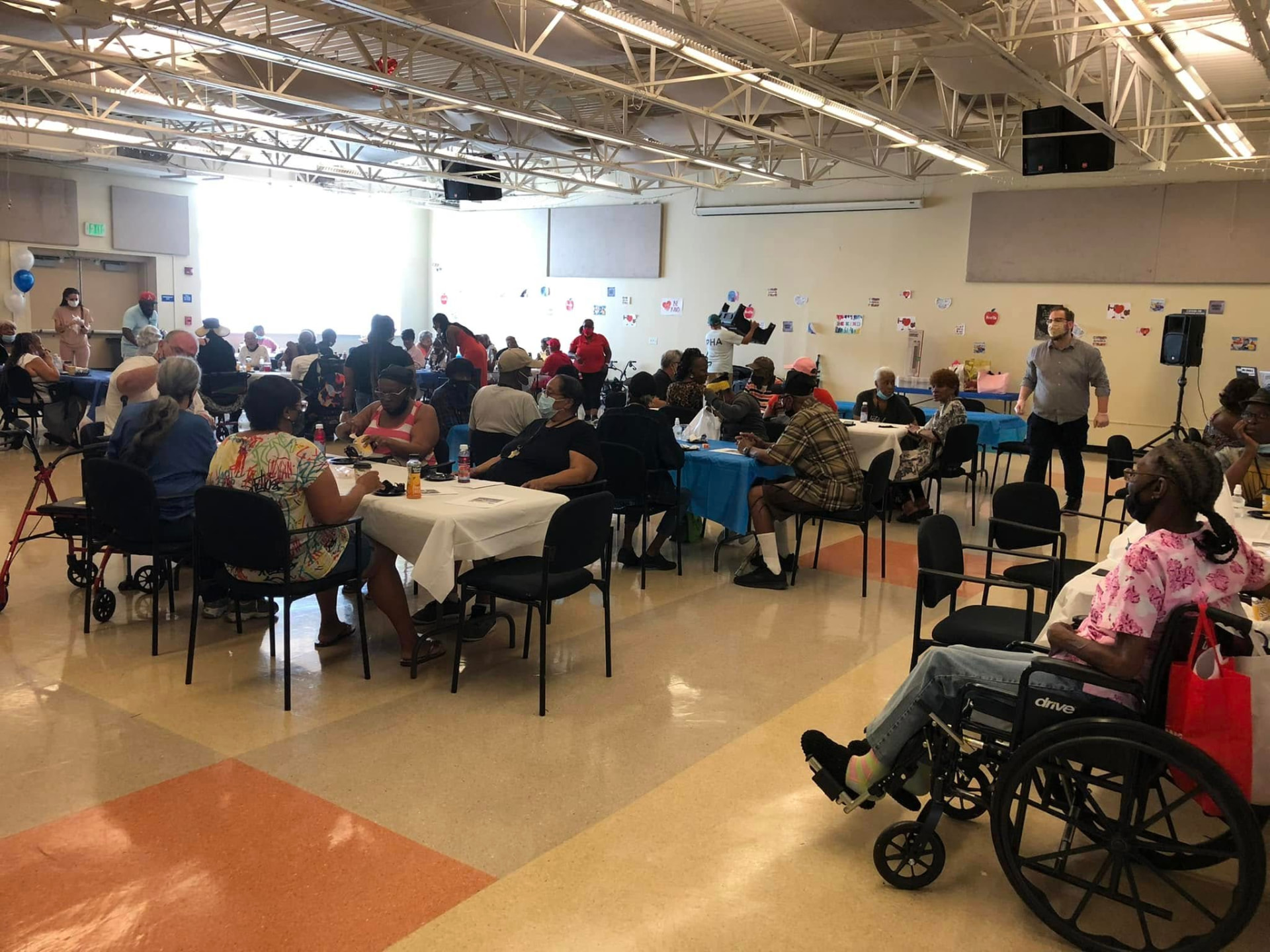Seniors seated at tables during a benefits education session at a senior center